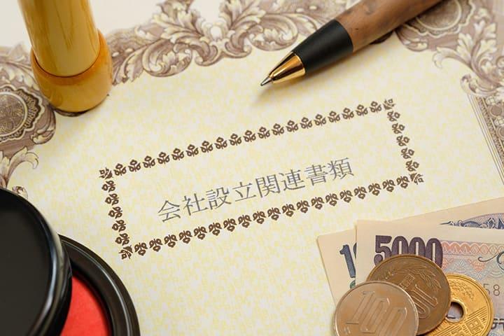 Pens, money, and seals placed around company incorporation documents