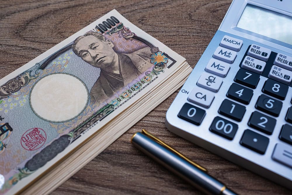 A bundle of Japanese 10,000 yen bills and a calculator.