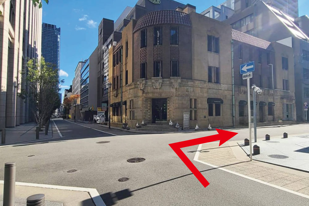 The brown exterior of the [Shibakawa Building] standing at the intersection.