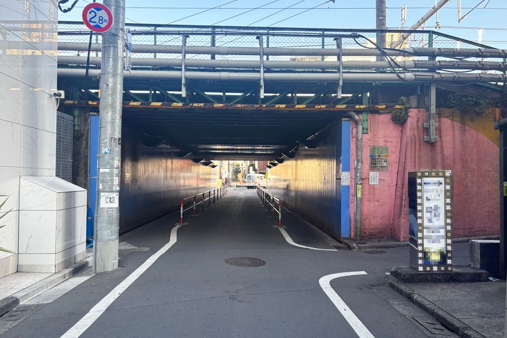 A tunnel beneath a railway viaduct.