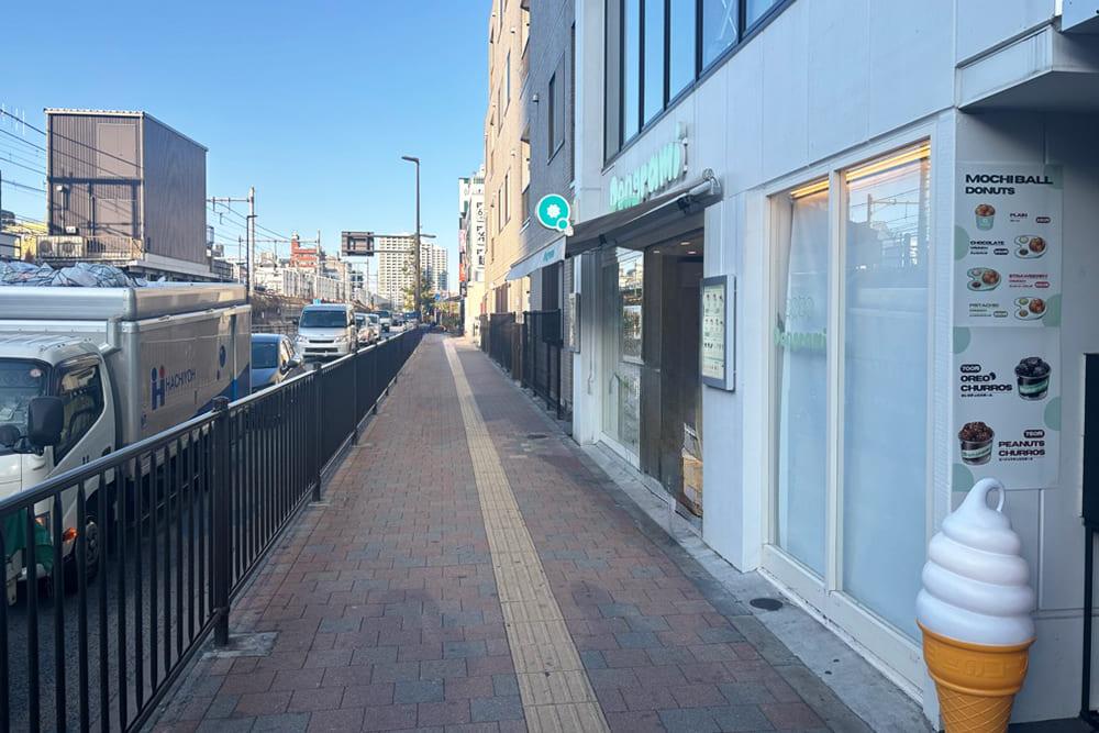 A sidewalk with a soft-serve ice cream figurine.