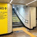 An underground passageway with yellow signs and stairs leading to Exit A13 of Ginza Station.