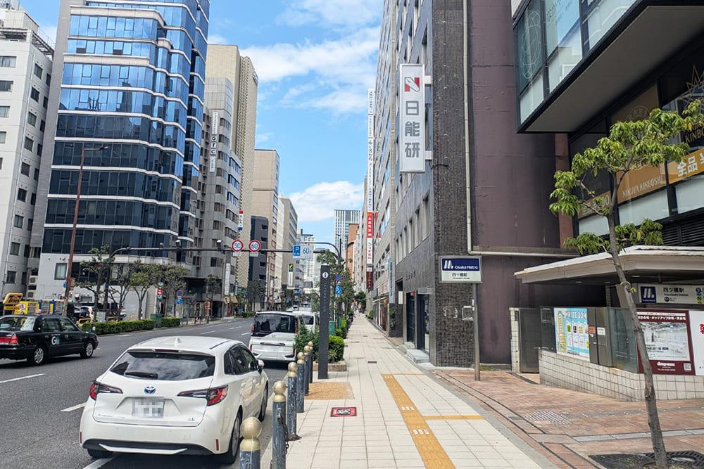 The sidewalk where you can see Exit 1-A of Yotsubashi Station and the Taiko Building.