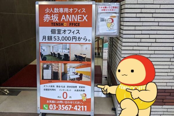 赤坂ANNEXオフィスの外看板を指さすてんしょうくん