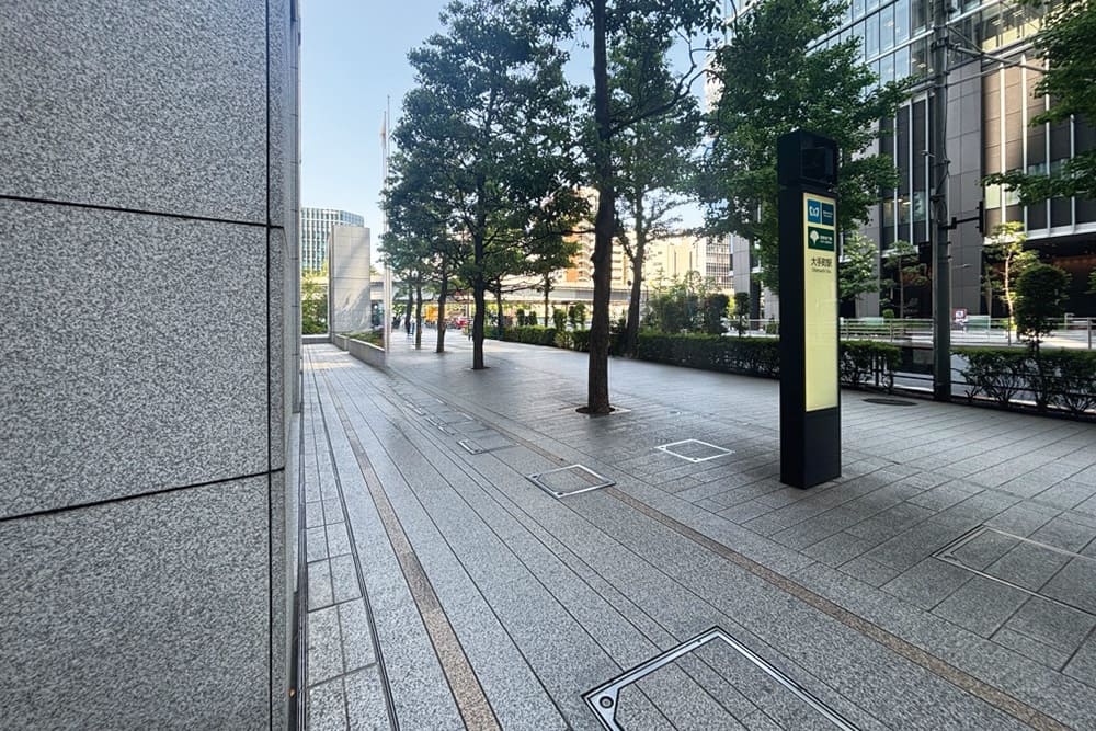 大手町駅付近の歩道。街路樹が並び、奥には高架が見える。