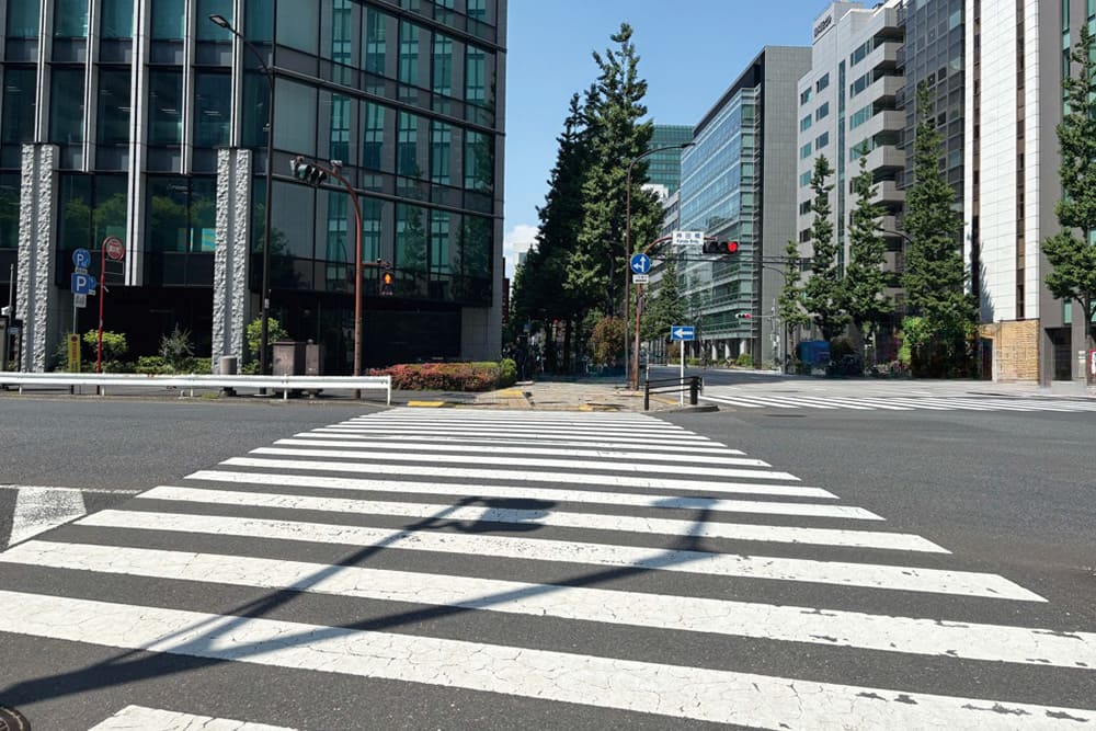 オフィス街の横断歩道。周囲には近代的なビルが立ち並ぶ。
