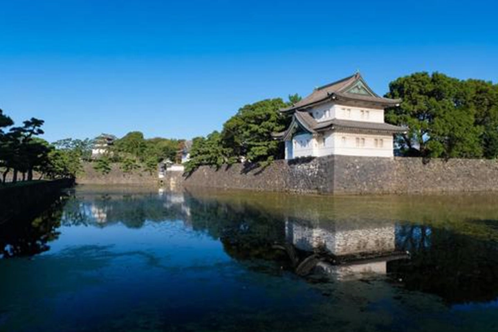 皇居外苑の風景。水面に映り込む石垣と、日本らしい伝統的な建物が美しい。