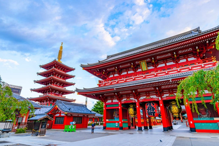 青空を背景に、浅草寺の朱色の本堂と五重塔が建ち並んでいる。