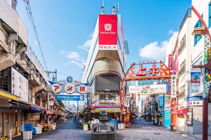 看板がひしめくアメヤ横丁の通り。活気ある商店街の風景が広がっている。