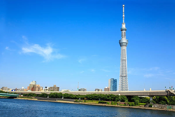 快晴の空の下、隅田川越しにそびえ立つ東京スカイツリー。