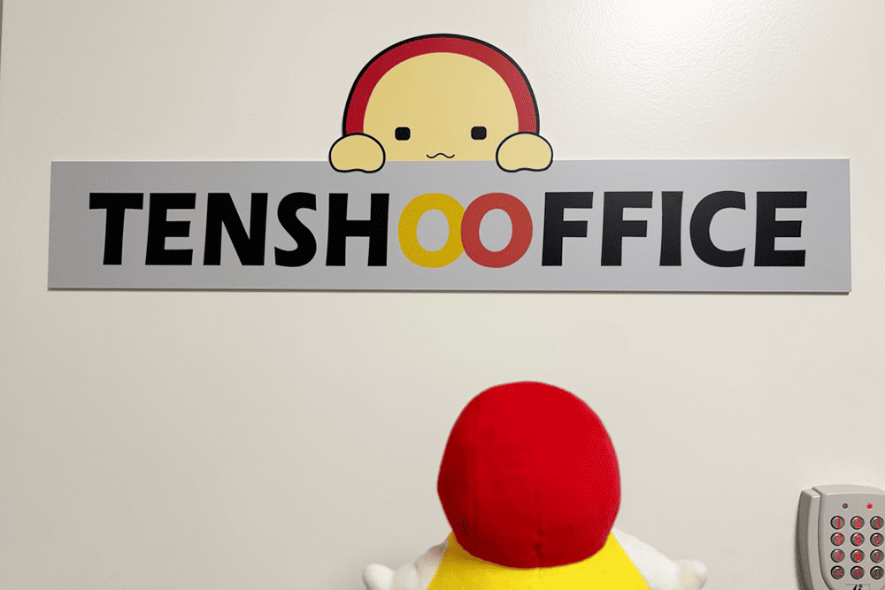 TENSHO OFFICEのドアプレートにいるてんしょうくんを見つめるてんしょうくんぬい
