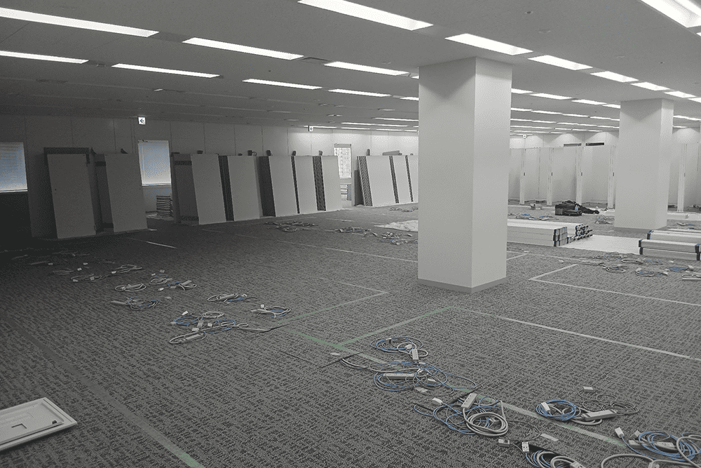 天翔オフィス天王洲ファーストタワーの正面左側の工事中画像_パーテーションが立て掛けられ、床にコードが散乱している