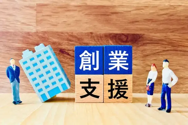 「創業支援」の文字が書かれたブロックとビルと人物